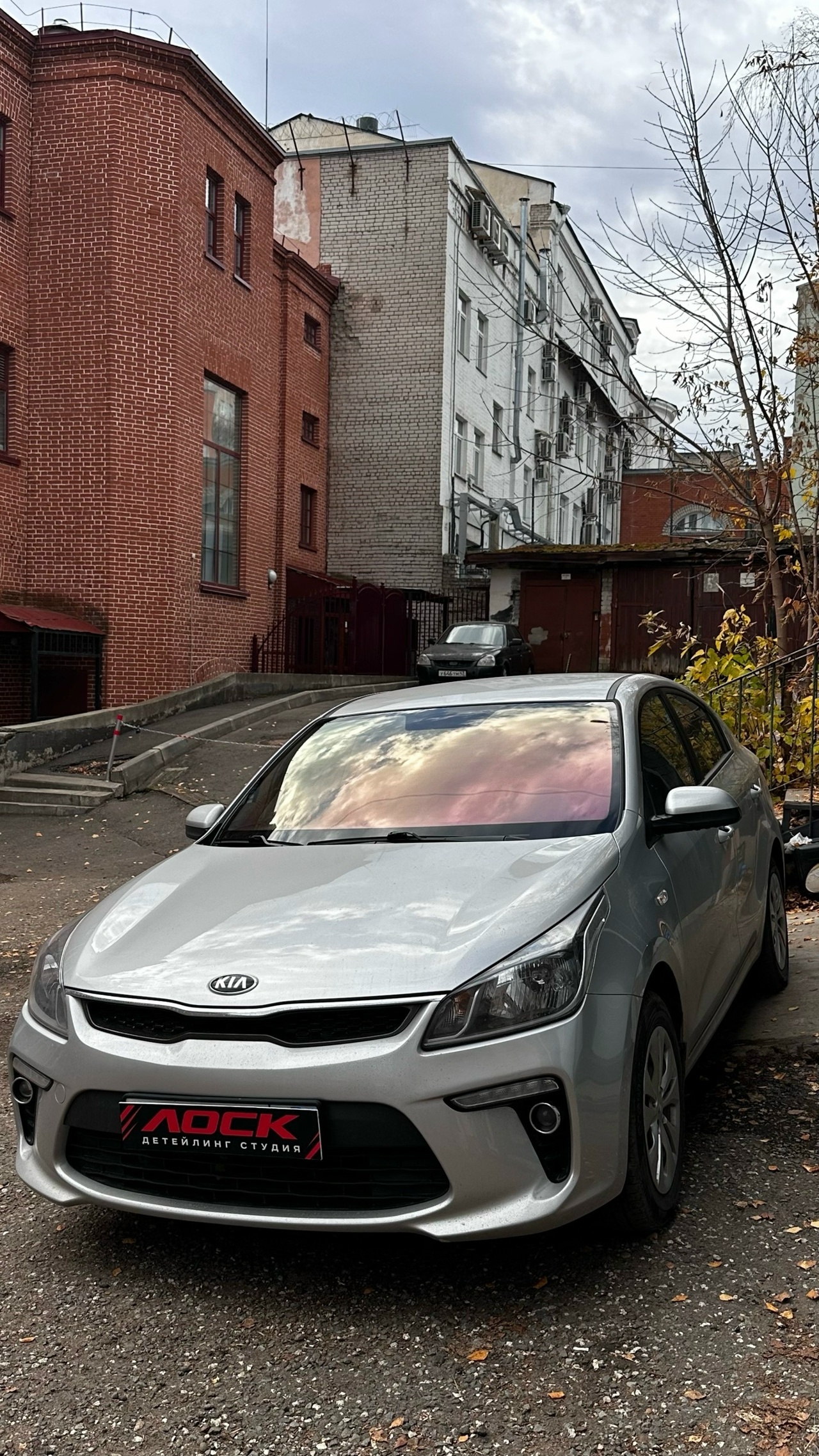 Серебристый Kia после тонировки стёкол во дворе студии