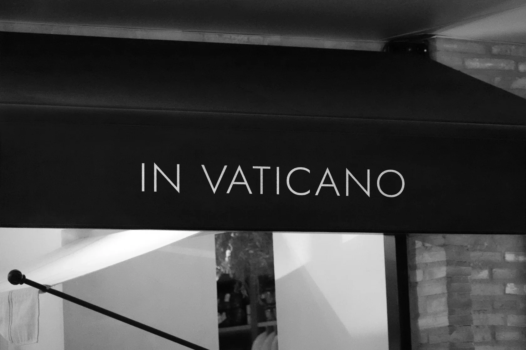 Логотип in Vaticano на чёрной маркизе ресторана