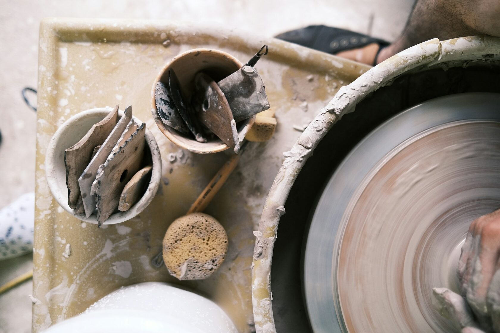Hands shaping clay at a ceramics workshop