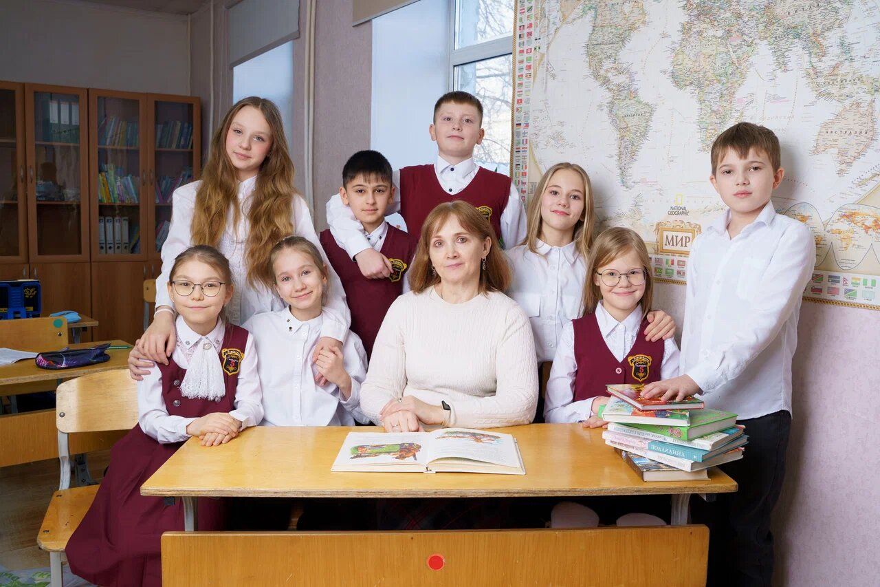 Класс начальной школы за партой у карты