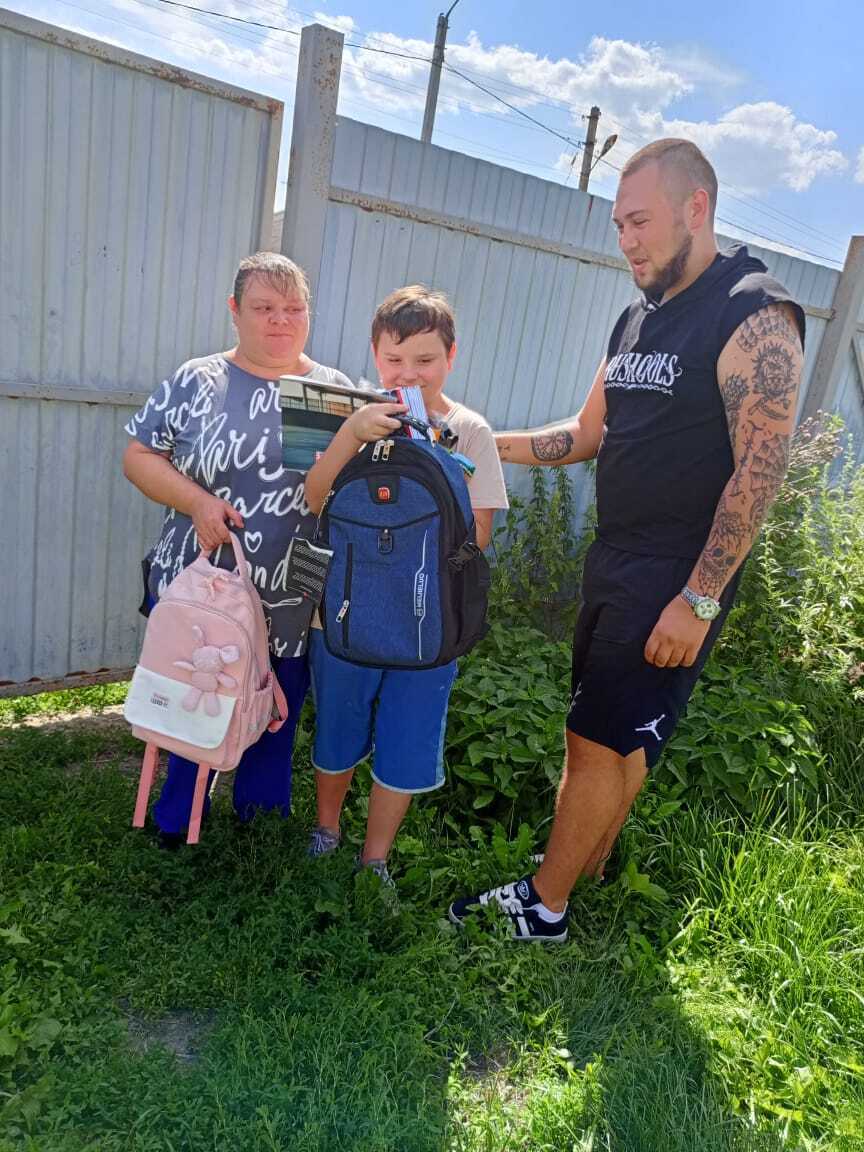 Семья с мальчиком у забора с рюкзаками