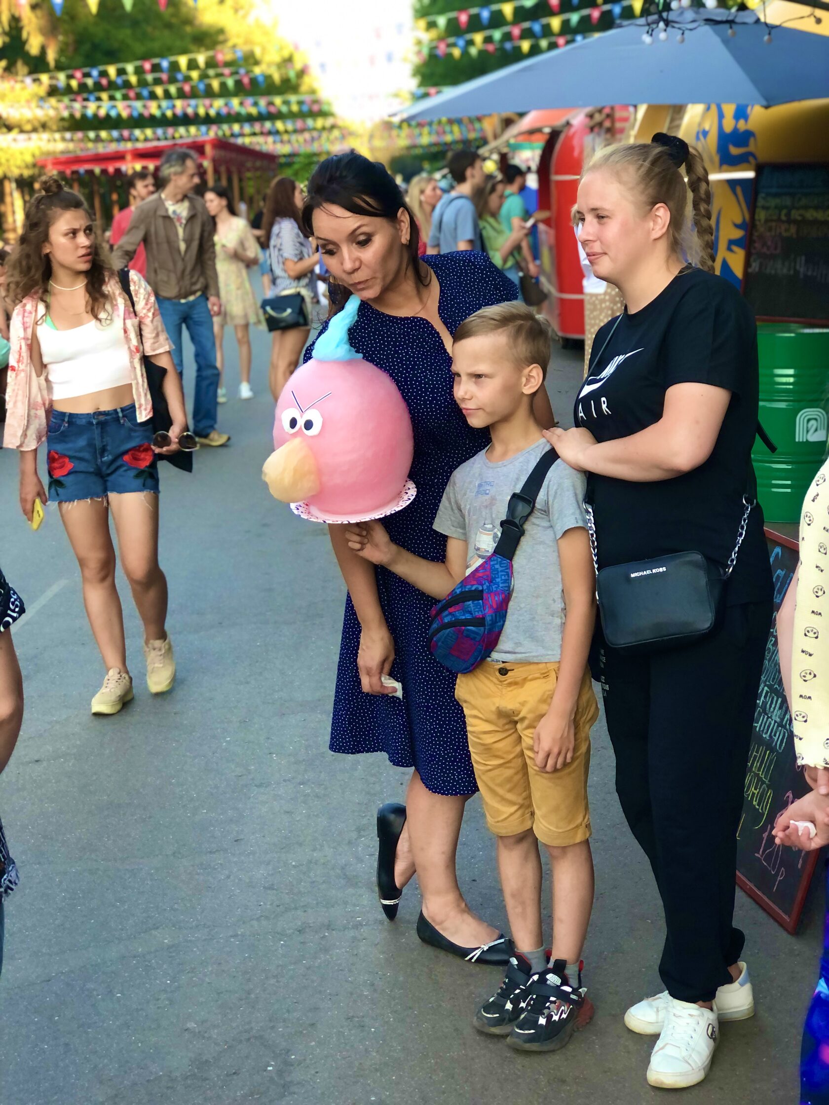 Семья с детьми и розовой фигурной сладкой ватой