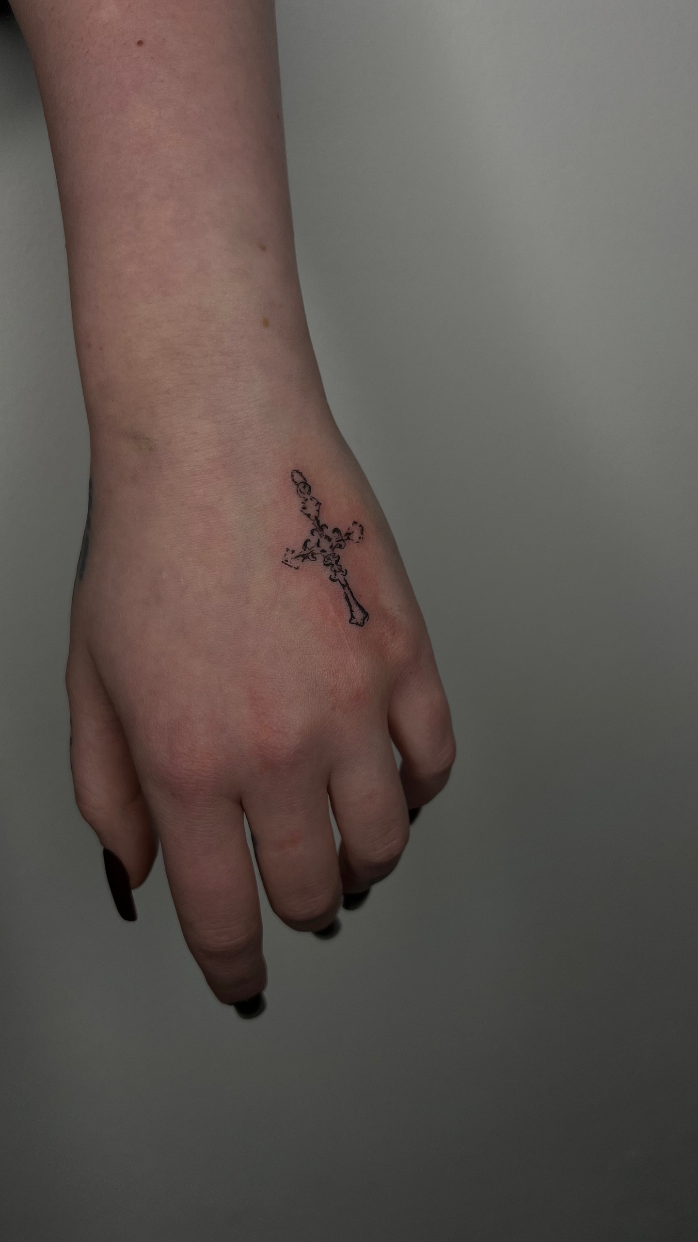 Cross delicate tattoo on hand