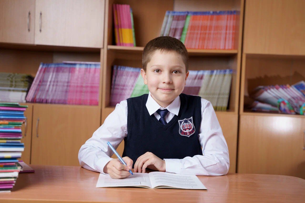 Ученик 4 класса пишет за партой