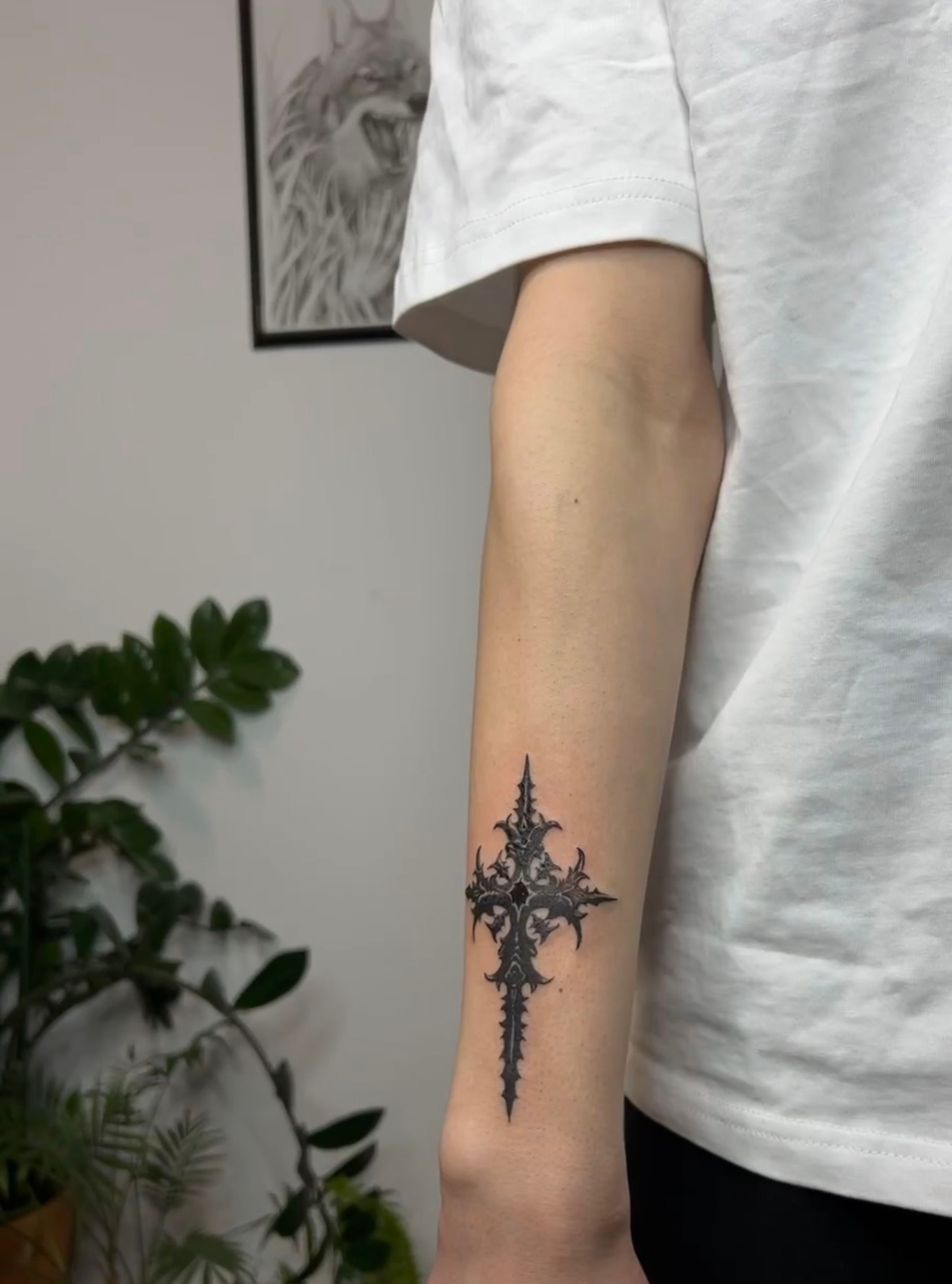 Ornate gothic cross tattoo on forearm