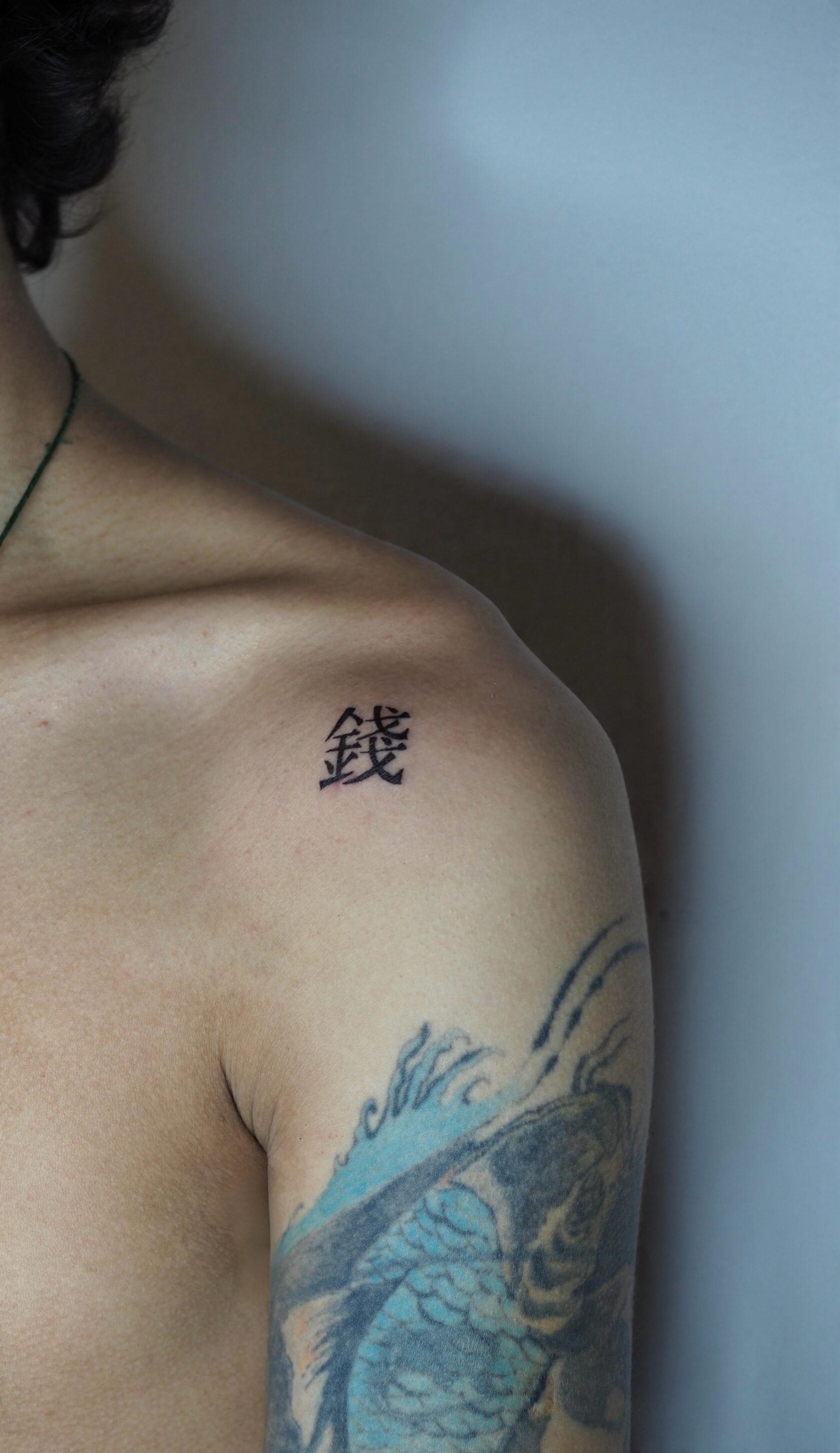 Fine line tattoo — иероглиф 錢 на плече