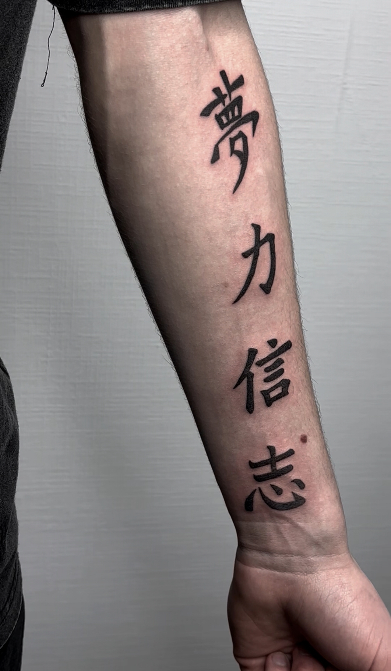 Chinese symbols tattoo on forearm