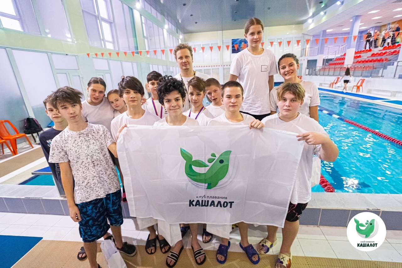 Команда клуба Кашалот с фирменным флагом у бассейна