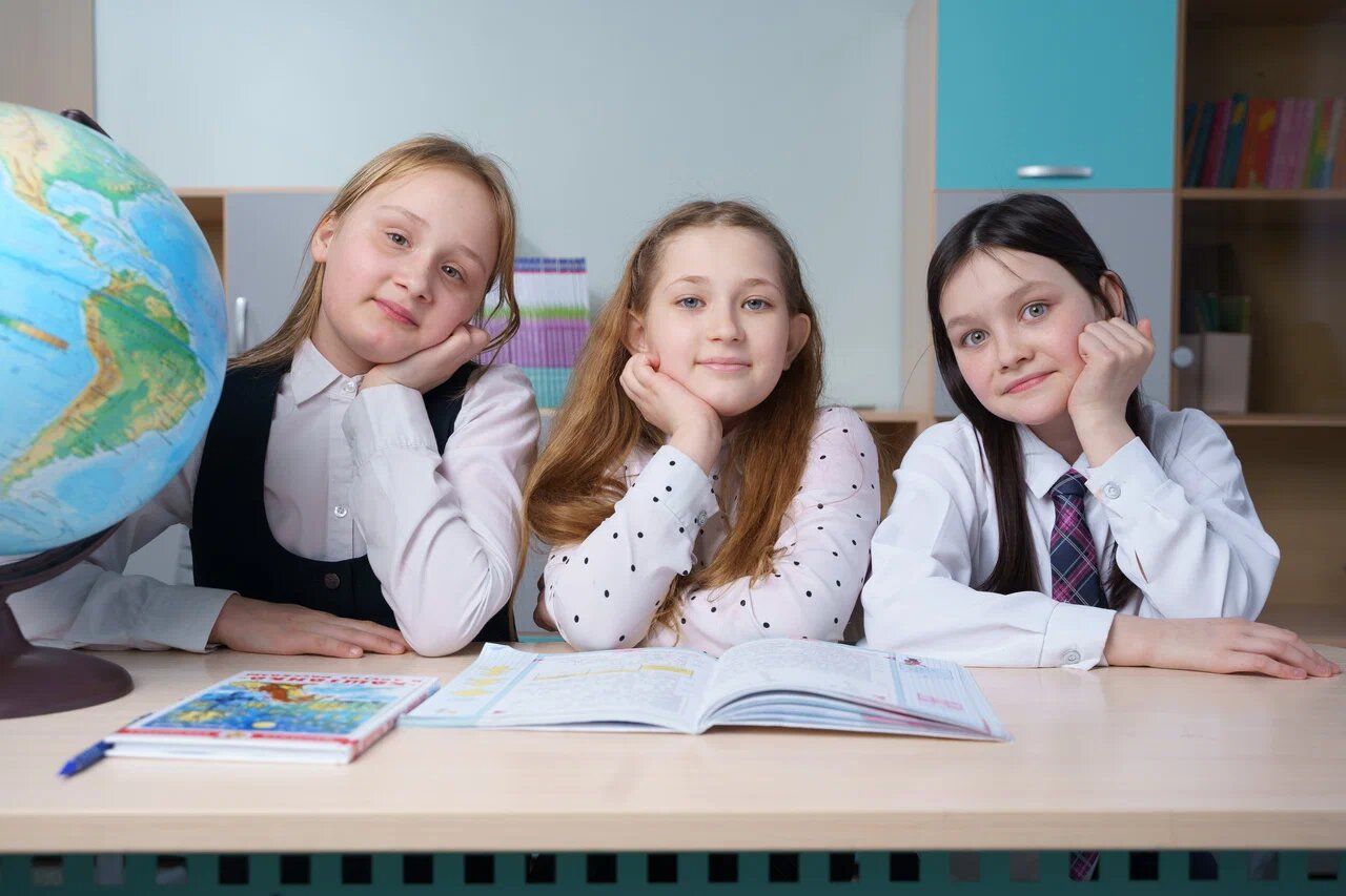Три ученицы 4 класса с глобусом за партой